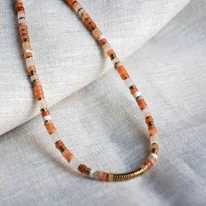 Macro view of natural semi-precious stone beads on a linen texture background