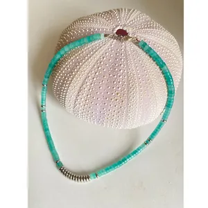 Close-up of turquoise semi-precious stone beaded necklace with silver spacers and ring details.