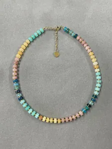 Detailed view of colorful natural semi-precious stone beaded necklace with gold heart charm