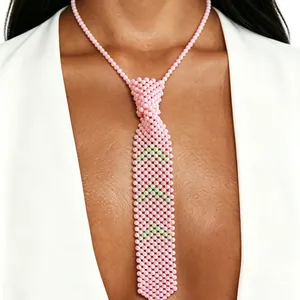 Détail exquis d'un collier cravate en perles roses avec des motifs de flèches vertes