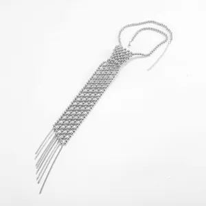 Détail du collier cravate en perles argentées avec des glands élégants et une chaîne