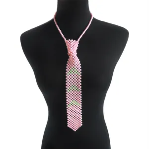 Gros plan sur un collier cravate en perles roses avec motifs verts sur mannequin