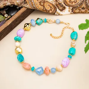 Close-up of vibrant irregular resin beads and golden accents on a bohemian style necklace