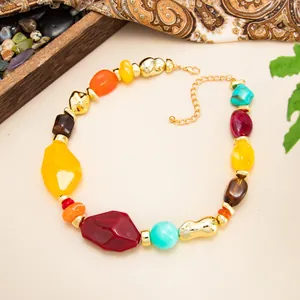 Macro view of colorful irregular marbled resin beads on a gold-plated fashion necklace