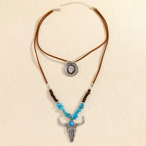 Westliche Boho-Lagenhalskette mit Türkisperlen und einem silbernen Stierschädel-Anhänger.