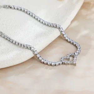Gros plan d'un bracelet de tennis étincelant en forme de cœur sur un support texturé blanc