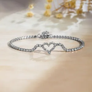 Bracelet tennis étincelant de couleur argentée avec un motif de cœur serti de cristaux.