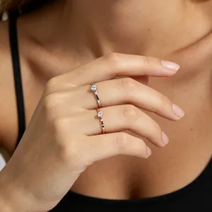 Detail of minimalist rose gold and silver titanium steel rings with cubic zirconia