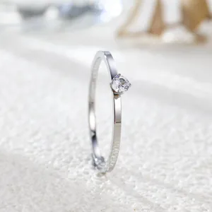 Macro view of a minimalist silver-toned titanium steel ring with a round zircon stone.