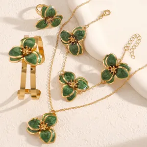 Vista detallada del elegante conjunto de joyas de flores esmaltadas verdes y oro