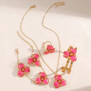 Vista detallada del conjunto de joyas de flores de esmalte rosa con collar