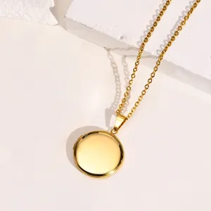 Vista detallada de un elegante collar con colgante de medallón redondo de acero dorado
