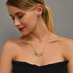 Close-up detail of a colorful crystal MOM pendant necklace worn by a female model