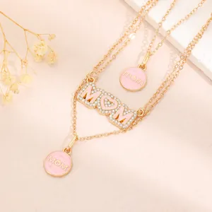 Detailed shot of gold-plated stainless steel Mother's Day necklace with pink MOM pendants