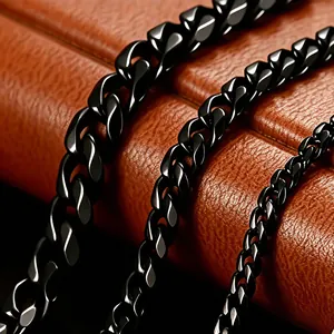Detailed macro view of high-shine black Cuban link chains on a brown leather texture