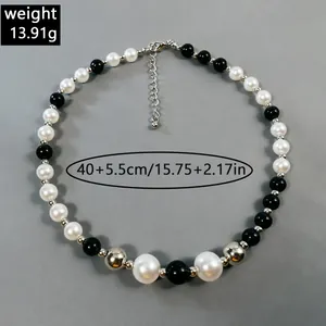 Vista detallada del elegante collar de perlas blancas y negras con info de dimensiones