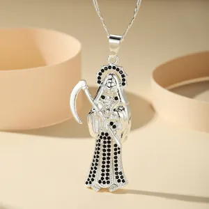 Detail view of silver Grim Reaper pendant with black stones and scythe