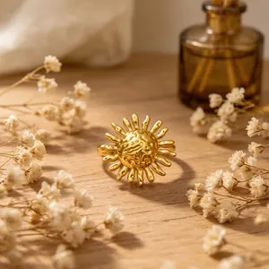 Vue macro détaillée d'une bague ouverte dorée en forme de soleil avec gravures