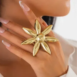 Bague fleur en métal doré surdimensionnée style soleil portée par un mannequin de mode