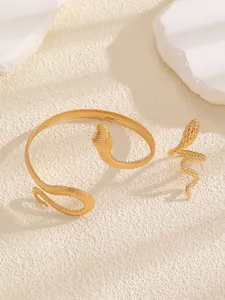 Detail view of the textured golden snake-shaped bracelet and adjustable open ring set