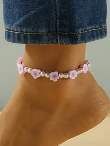 Detalle de tobillera con flores de arcilla polimérica rosa y perlas artificiales