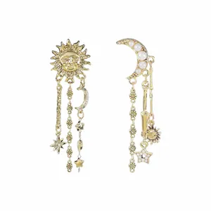 Primo piano di orecchini vintage oro con sole e luna che mostrano trame intricate.