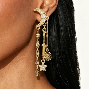 Eleganti orecchini vintage dorati con pendenti a luna stella e sole sull'orecchio