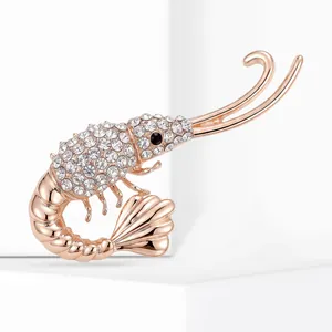 Gros plan d'une broche homard en or rose avec strass étincelants et détail d'œil noir.