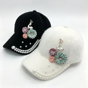 Gros plan sur les décorations élégantes en fleurs et perles sur casquettes.