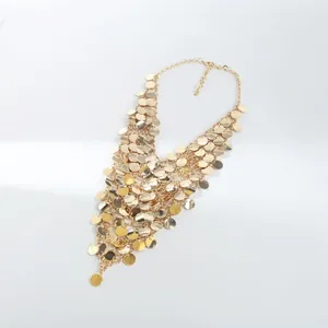 Dettaglio ravvicinato di nappe di paillettes dorate su una collana a più strati moda