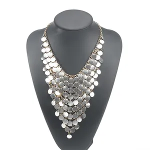 Dettaglio della collana con nappine di paillettes argentate a più strati su busto nero