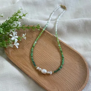 Detail of bohemian seed bead necklace with irregular freshwater pearls on a wooden tray