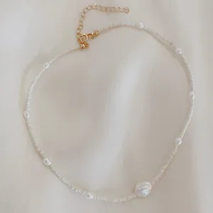 Detailed macro view of bohemian seed bead choker featuring irregular white freshwater pearls