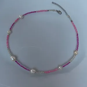 Close-up of bohemian necklace with pink seed beads and irregular freshwater pearls
