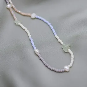 Close-up detail of bohemian rainbow seed bead necklace featuring irregular freshwater pearls