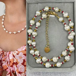 Detail of bohemian freshwater pearl necklace with gold heart charm in a jewelry box.