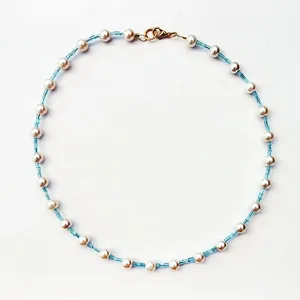 Detail view of Bohemian choker with white pearls and light blue glass seed beads.