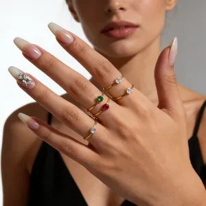 Detailed macro view of minimalist 14K gold thin rings with colorful gemstones on hand
