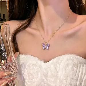 Elegante Goldkette mit lila Kristall-Schmetterlingsanhänger, präsentiert an einem Model