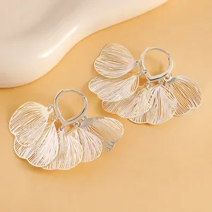 Close-up view of silver hollow fan-shaped floral petal hoop earrings for women