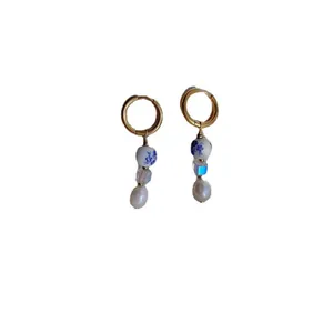 Dettaglio degli orecchini in porcellana bianca e blu con perle naturali d'acqua dolce