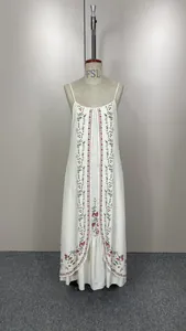Détail d'une robe maxi sans manches blanche brodée de fleurs avec ourlet ample