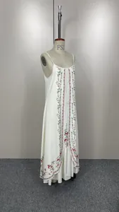 Détail d'une robe longue blanche à imprimé floral sur un mannequin de couture.
