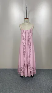 Vue d'une robe longue rose à bretelles avec broderies florales sombres sur un mannequin.