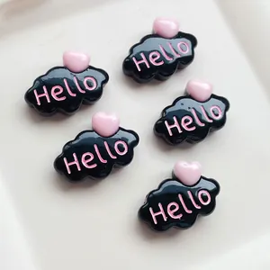 Gros plan sur des breloques en résine nuage noir avec cœurs roses et texte 'Hello' DIY