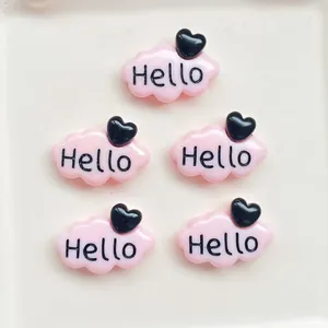 Vue rapprochée d'accessoires nuages en résine rose avec texte 'Hello' et cœurs.