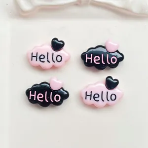 Gros plan d'accessoires en résine rose et noir en forme de nuage avec texte Hello