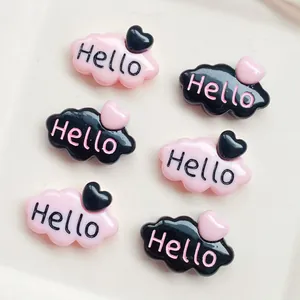Vue détaillée de breloques nuages en résine noir et rose avec texte Hello et cœur