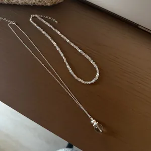 Detail view of clear irregular crystal crushed stone necklace and orb pendant