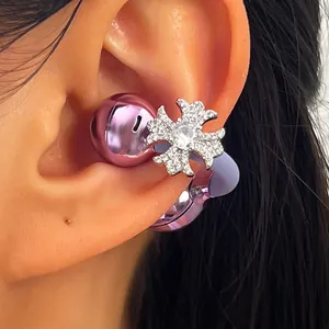 Primer plano de un clip para auriculares morado con diseño de cruz de circón